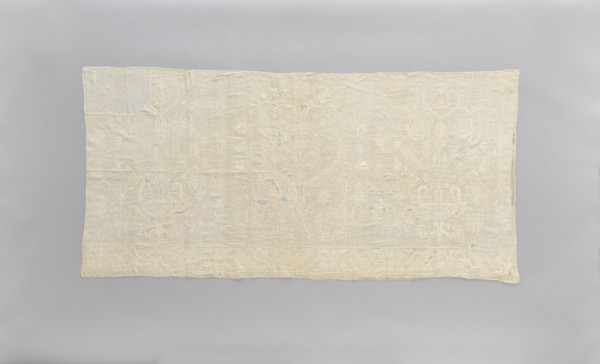 Church napkin made of white linen, covered with white, partially openwork embroidery. In the center
