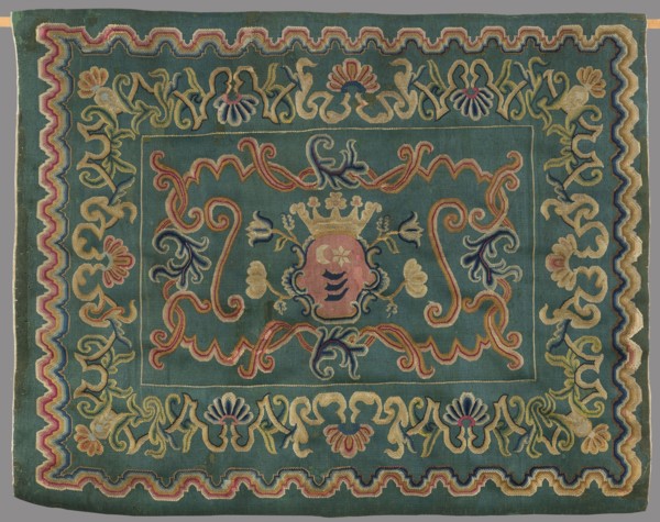 Kilim, In the center of the main field is a shield composed of ogee and rooster combs – the Wolda