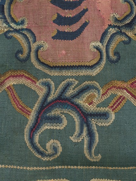 Kilim, In the center of the main field is a shield composed of ogee and rooster comb motifs — the