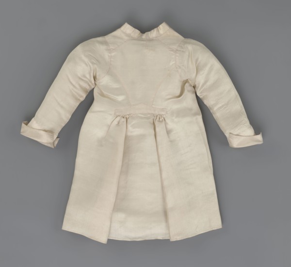 Children's dress made of cream satin. Long, fitted at the top, slightly flared at the bottom.