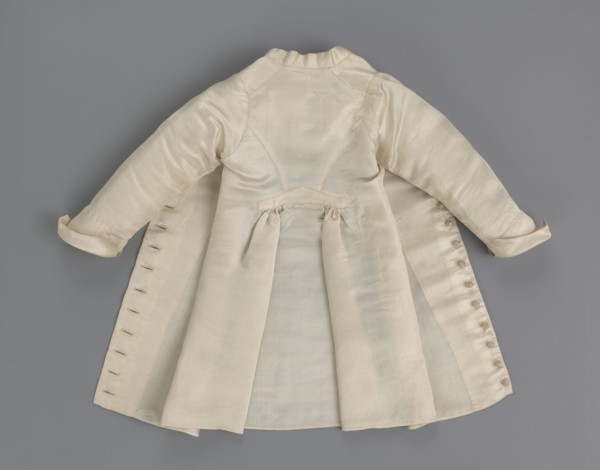 Children's dress made of cream satin. Long, fitted at the top, slightly flared at the bottom.