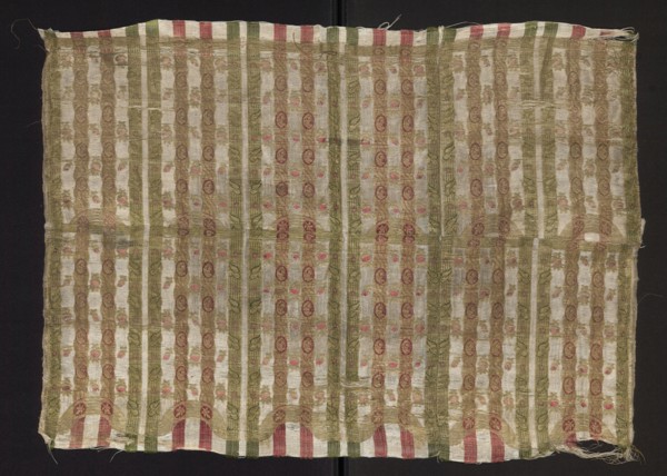 Fragment of silk fabric with fine stripes and a stylized plant ornament. Predominant colors: