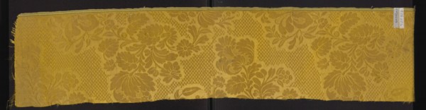 Fabric fragment, silk damask fragment, patterned floral motifs, preserved selvedge. Yellow damask
