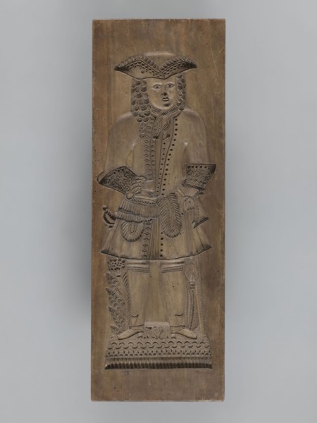 Double-sided gingerbread mould. Side A: image of a bachelor; Side B: baby in swaddling clothes.,
