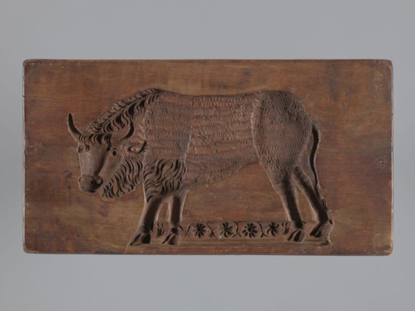 Double-sided gingerbread mould. Side A: bison; Side B: three representations — a bachelor in early