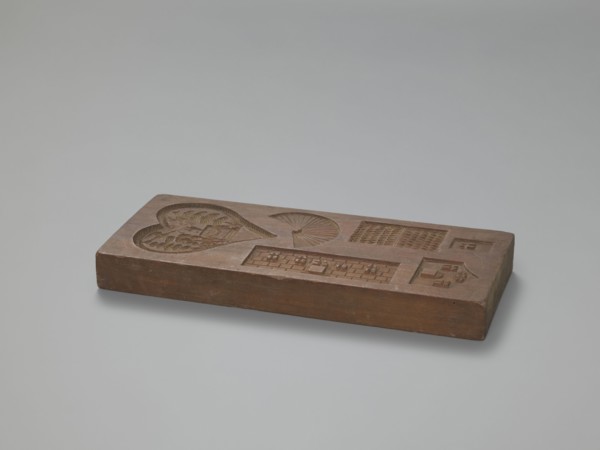 Double-sided gingerbread mould. Obverse: three hearts formed from laurel leaves, each containing