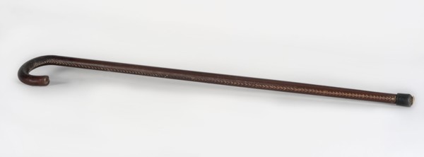 Walking stick, maker, wooden walking stick covered with brown leather along its entire length,