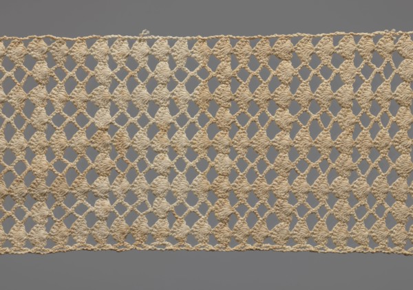 Fragment of crocheted lace, section of a belt, cream-colored, with motifs of semicircular shells