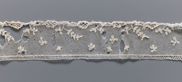 Fragment of needle lace of the point d'Alençon type. Cream, with a mesh background of twigs,