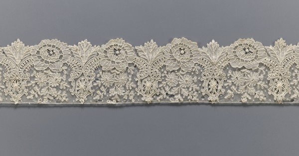 Lace fragment, purchase provenance noted; lace with plant ornaments. Serrated on one side, with a