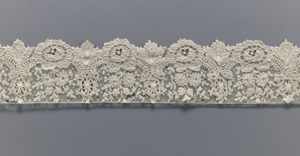 Lace fragment, lace with plant ornaments. Serrated on one side, with a pattern of flowers,
