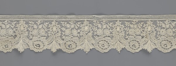 Lace fragment, lace with plant ornaments. Serrated on one side, with a pattern of flowers,