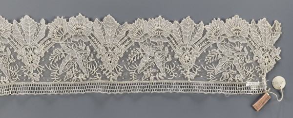 Lace fragment, Plant ornaments; pattern of stylized leaves and flowers, serrated on one side.
