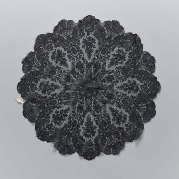 A fragment of lace umbrella cover, lace; patterns arranged radially from a central rosette; outer