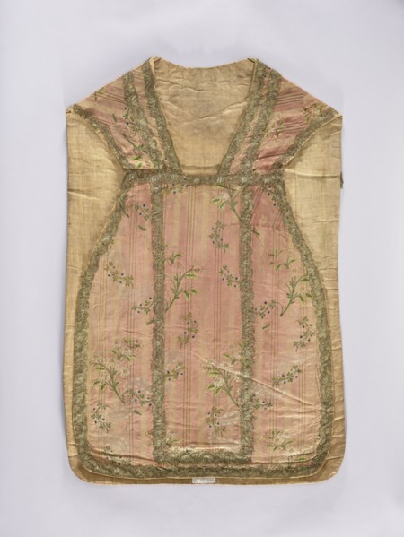 Chasuble, liturgical vestment;, noted. A large floral pattern and lace motif are set against a