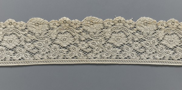 Lace fragment, machine-made lace, strip serrated on one side in accordance with the forms of
