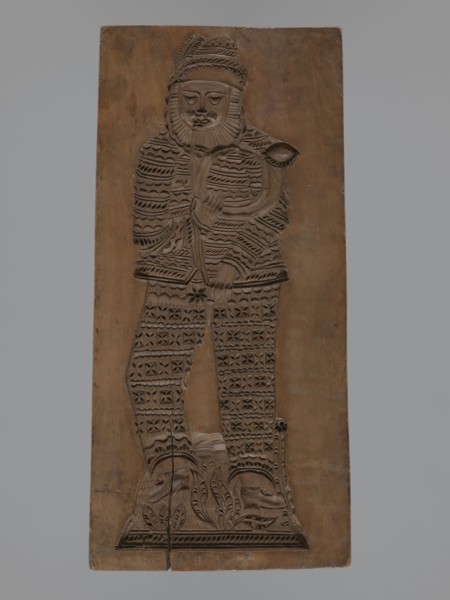 Double-sided gingerbread mould. Obverse: figure of a bearded man playing a horn; reverse: several