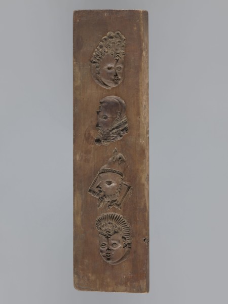 Double-sided gingerbread mould. Obverse: images of four heads; on rotation heads take on male or