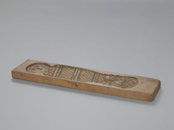 Double-sided gingerbread mold. Obverse: baby in swaddling clothes richly decorated with various