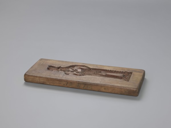Double-sided gingerbread mould. Side A: figure of a soldier. Side B: various floral and geometric