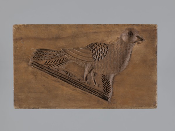 Double-sided gingerbread mold. Obverse: male figure in a high hat and fur-lined jacket sitting on a