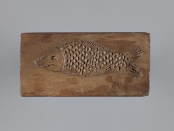 Double-sided gingerbread mould. Obverse: stylised elongated fish covered with scales, shown in