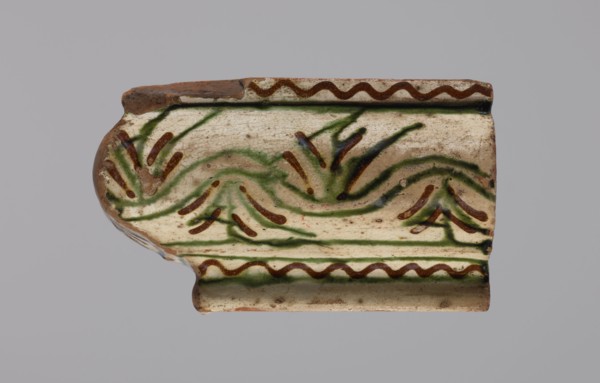 Cornice tile fragments 4, painted with a wavy twirl pattern; tile cullet; stoves; plant