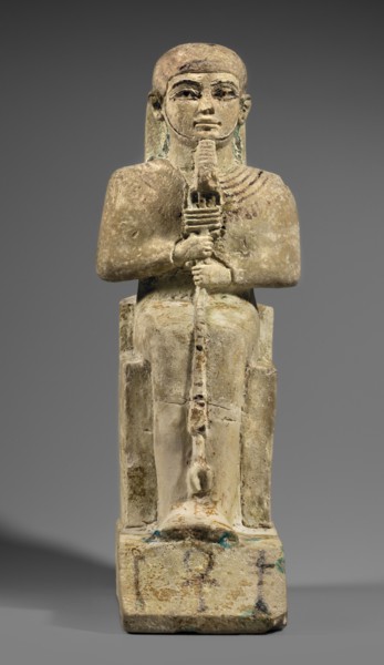 Figurine of the god Ptah sitting on a throne, on a base in the shape of the sign of Maat. He holds