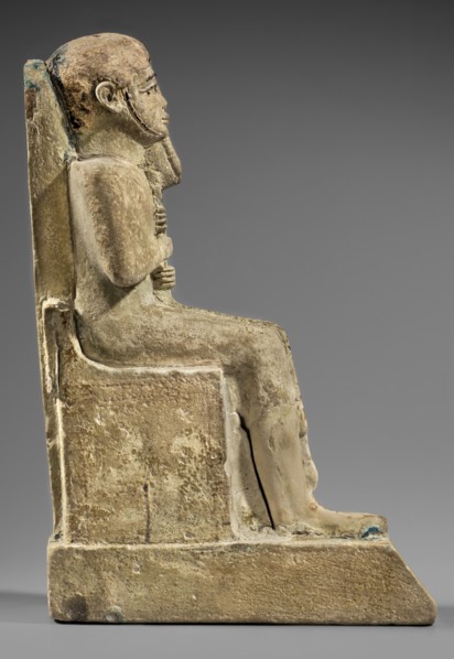 Figurine of the god Ptah sitting on a throne, on a base in the shape of the sign of Maat. He holds