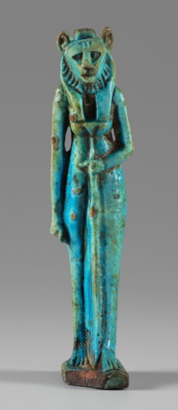 Amulet — figurine of a lion-headed goddess. A lion-headed goddess, in a tripartite wig and a narrow