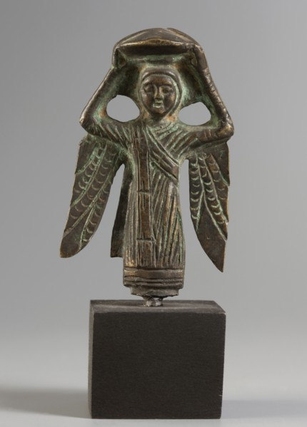 Figurine of a winged woman. Figurine depicting a woman standing frontally. Round face with clearly