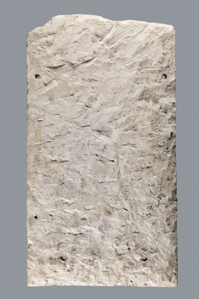 Small limestone stele with simple architectural decoration. Recessed epigraphic field surrounded by