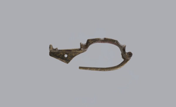 Arched fibula, unknown Roman workshop. Fibula with an arched hoop decorated with two crossbars and