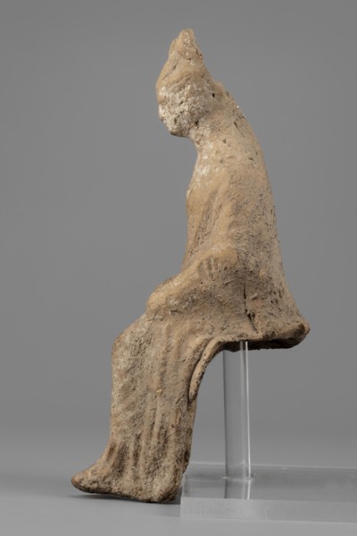 Female figurine. Female figure in a seated position, slightly leaning forward. The back of the