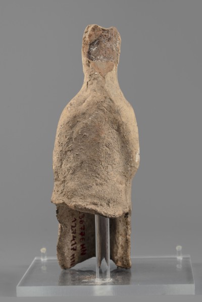 Female figurine, Female figure in a seated position, slightly leaning forward. The back of the
