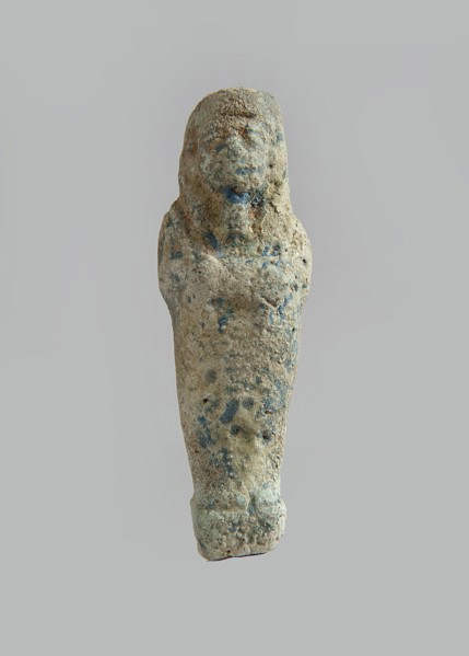Ushabti. Carelessly made figurine with schematic facial features, in a narrow wig revealing the