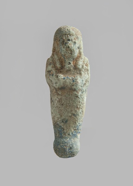 Ushabti. Carelessly made figurine with schematic facial features, in a narrow wig revealing the