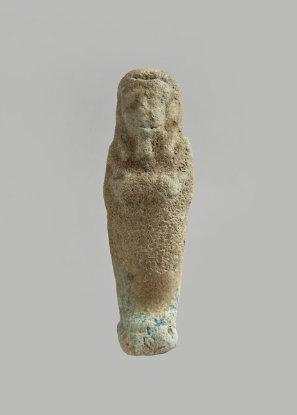 Ushabti. Carelessly made figurine with schematic facial features, in a narrow wig revealing the
