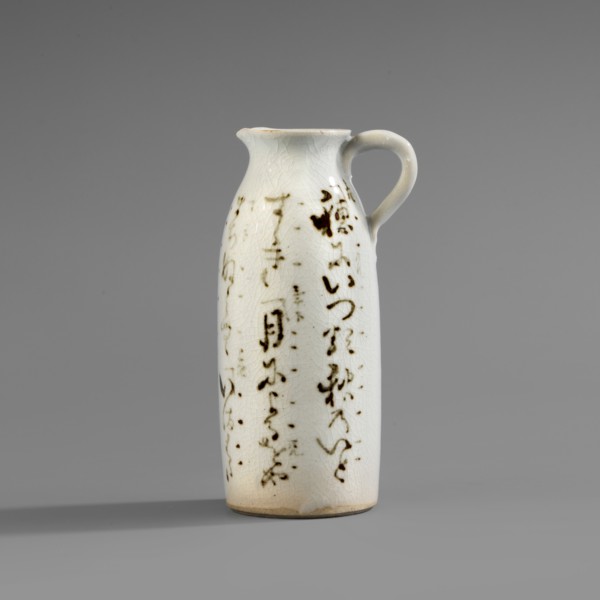 Cylinder-shaped jug with small handle and widened spout. White glaze with fine crackle; decoration