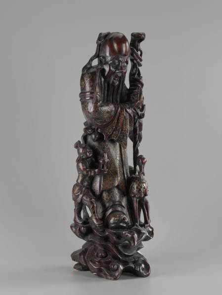 Deity of Longevity Shouxing/Shoulao holds a long traveling staff and a peach of immortality. His