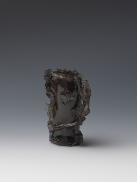 Vase on base, carved ornaments; wooden base, oval on three legs. Carved decoration: stylized rocks,