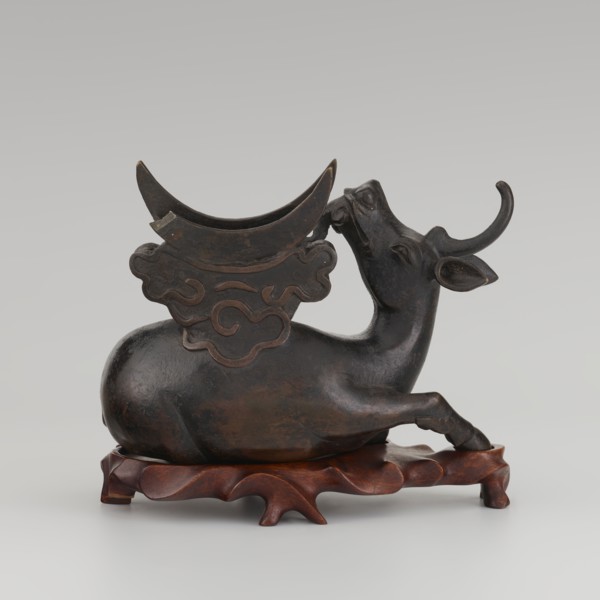 Mirror with TLV decoration on a pedestal in the form of a qilin on a base. Chinese; Qing dynasty