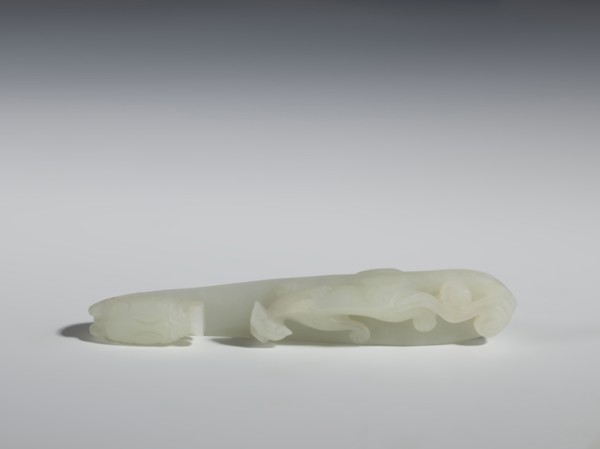 Belt clasp;, Milky-white, slightly translucent jadeite with slight colloid clusters. Carved and