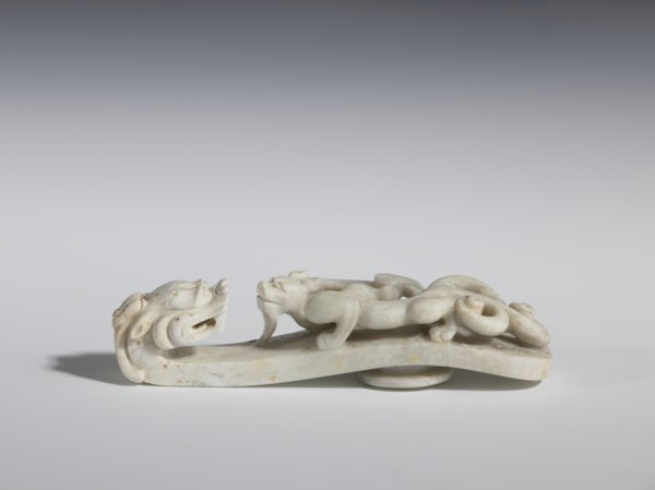 Belt clasp. Handle: stylized lizard-dragon qilong. Milky-white jadeite. Full-plastic carved head,