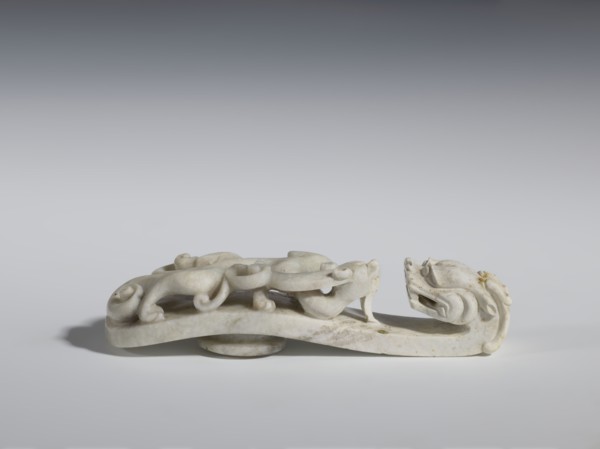 Belt clasp. Handle: stylized lizard-dragon qilong. Milky-white jadeite. Full-plastic carved head,