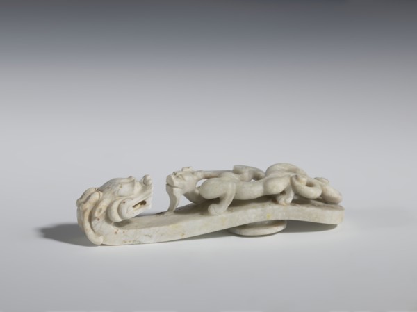 Belt clasp. Handle: stylized lizard-dragon qilong. Milky-white jadeite. Full-plastic carved head,