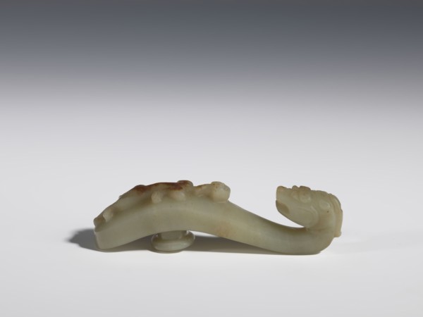Belt clasp. Handle flattened on the sides, decorated with a lizard-dragon motif. Jadeite with