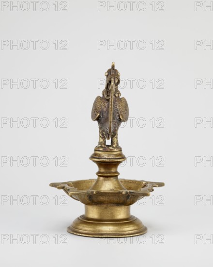 Oil lamp, Round base with a pentagonal vessel for oil topped by a bird figurine rooster/swans/geese