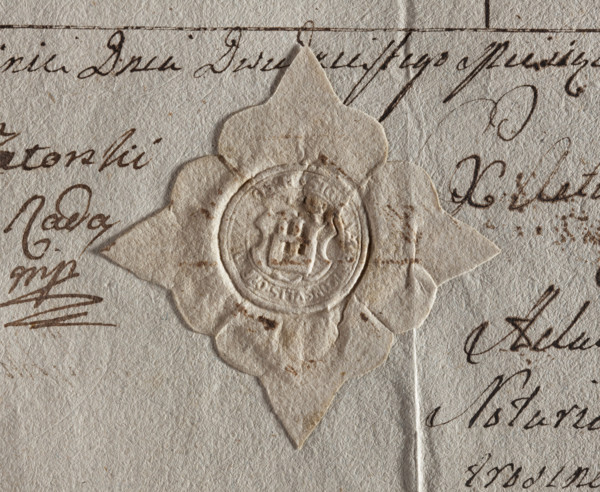 Round seal impression of the town of Jutroszyn, Kalisz Voivodeship. On the shield there is a wall