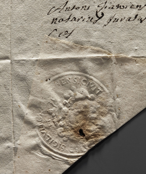 Round seal impression of the city of Olsztyn. On a round, richly decorated, crowned shield, an